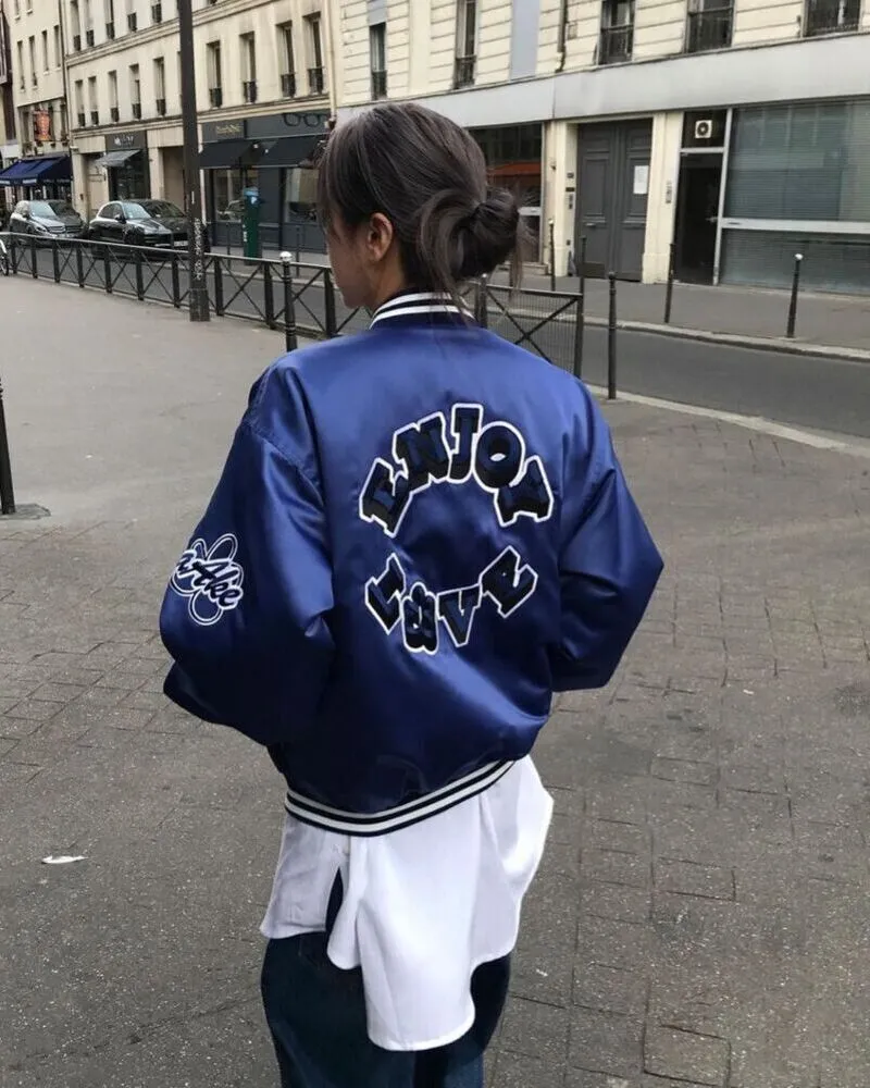 female wearing blue custom varsity jacket walking in la streets