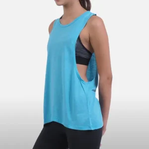 A side view of a woman wearing a bright light blue loose-fitting tank top with wide armholes, layered over a black sports bra.